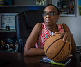 Lori Latrice Martin sitting while holding a basketball