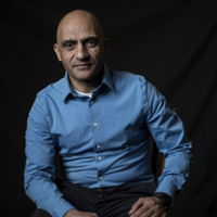 Ehab Meselhe wearing a blue shirt in front of a black background