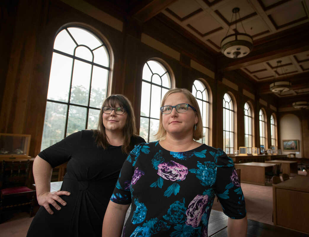 Hayley Johnson and Sarah Simms standing beside each other in a library